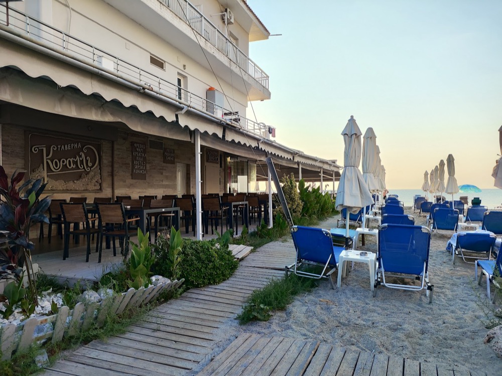 Beachfront terrace and sunbeds at Taverna Koralli